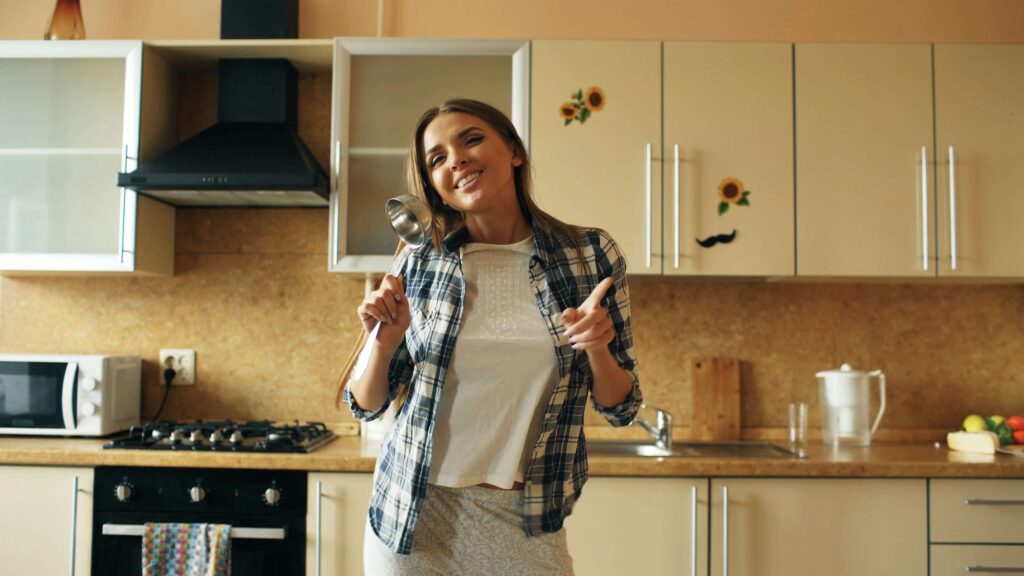 A smiling and confident looking girl in the kitchen.